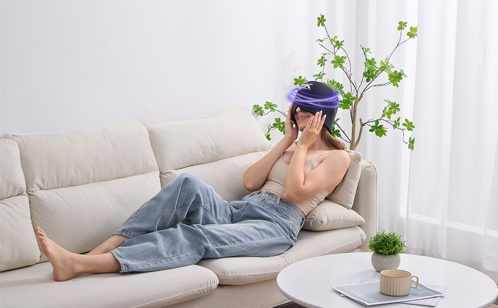Woman relaxing on a sofa wearing the K2K Migraine Relief Cap